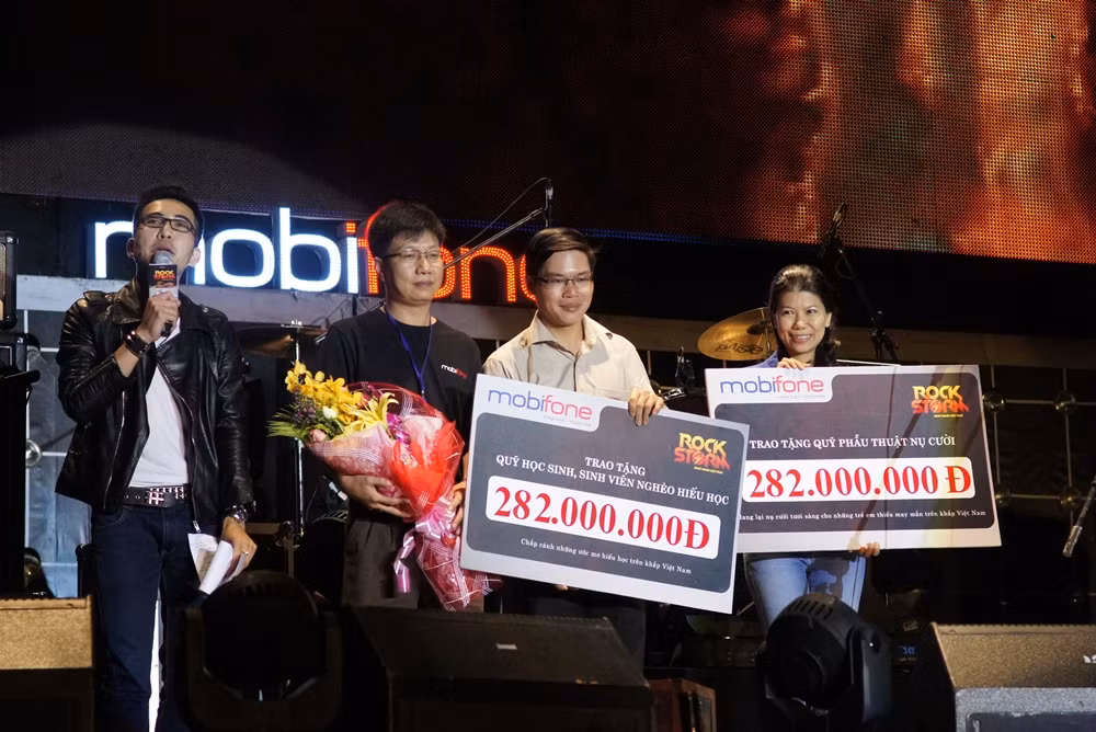 Đại diện MobiFone trao tặng số tiền từ thiện cho Quỹ Phẫu thuật nụ cười (ngoài cùng bên phải) và Quỹ Học sinh – sinh viên nghèo hiếu học của Trung ương Đoàn trên sân khấu RockStorm TP.Hồ Chí Minh