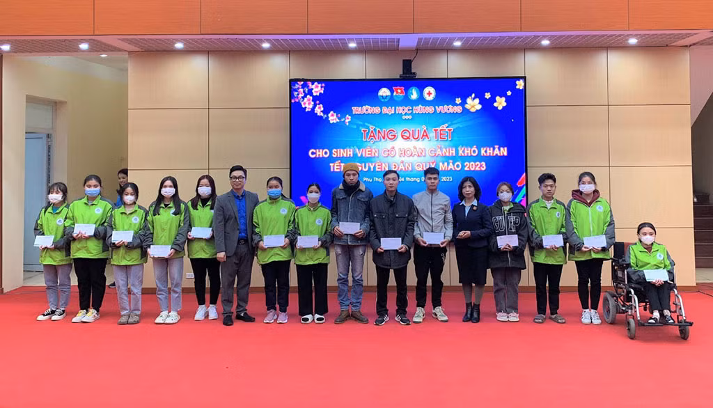 Phó giáo sư Phan Thị Tình (đứng thứ 5, từ bên phải sang) cùng đại diện các tổ chức đoàn thể Trường Đại học Hùng Vương trao quà cho các sinh viên có hoàn cảnh khó khăn vươn lên trong học tập. Ảnh: website nhà trường