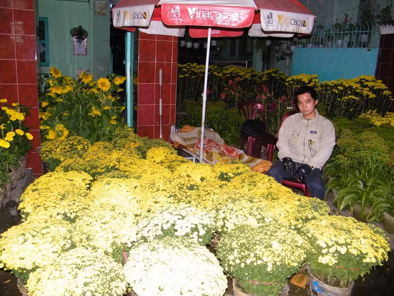 Trời gần sáng, Dũng đang mệt mỏi ngồi giữa cái lạnh, dõi mắt trong đêm, canh chừng hoa thay chọ người chị trùm chăn ngủ ngủ (ảnh chụp trên đường Lê Quang Định, Q.Bình Thạnh).