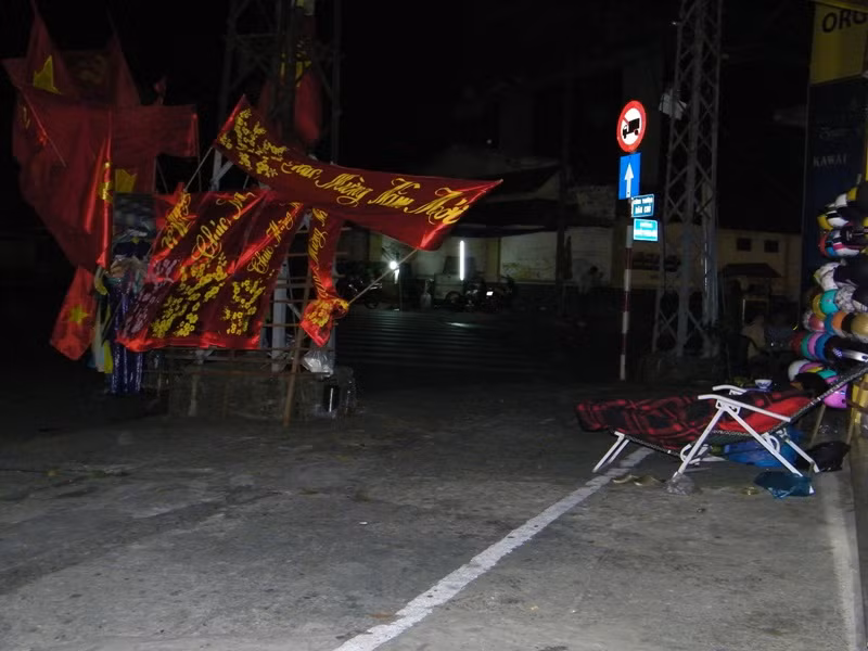 Gần đó, người phụ nữ bán cờ, bandrol chúc mừng năm mới nằm trên chiếc ghế xếp, đang ngủ say sưa giữa trời Sài Gòn trời lạnh giá.