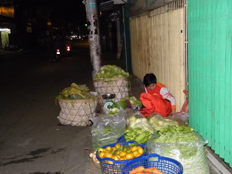 2 giờ 15 sáng, con đường Cách Mạng Tháng 8 (Q.3) vắng vẻ người, xe. Cậu bé tên Tài vẫn đang loai hoay với đống rau, củ bên vỉa hè. Tài cho biết: “Em đang thay mẹ canh hàng. Mẹ đang đi lấy rau củ ở chợ đầu mối về để sáng nay bán”.