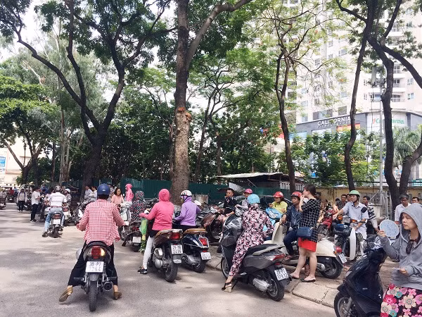 Hình ảnh các vị phụ huynh xếp hàng dài ngoài đường chờ con em mình dưới cái nắng oi bức, cùng vẻ mặt lo lắng, căng thẳng (Ảnh: Ngọc Bích) Hình ảnh các vị phụ huynh xếp hàng dài ngoài đường chờ con em mình dưới cái nắng oi bức, cùng vẻ mặt lo lắng, căng thẳng (Ảnh: Ngọc Bích)