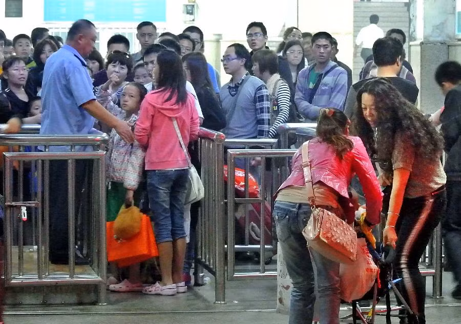Chen chúc nhau qua cửa soát vé