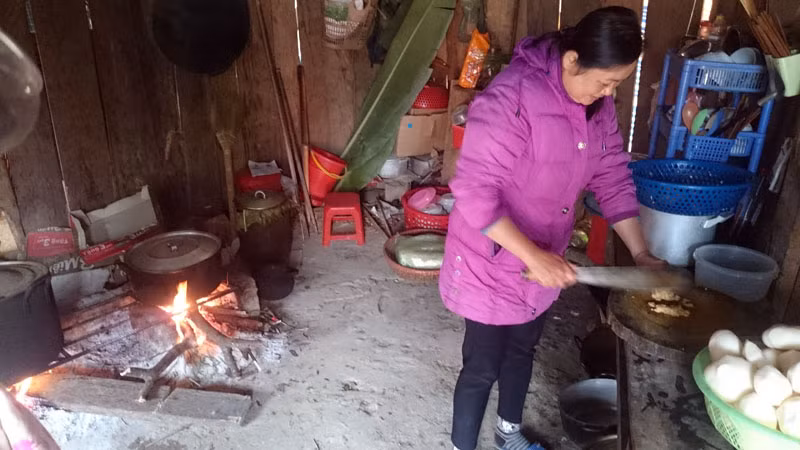 Trong ảnh một cô giáo đang chuẩn bị bữa trưa cho học sinh bán trú.