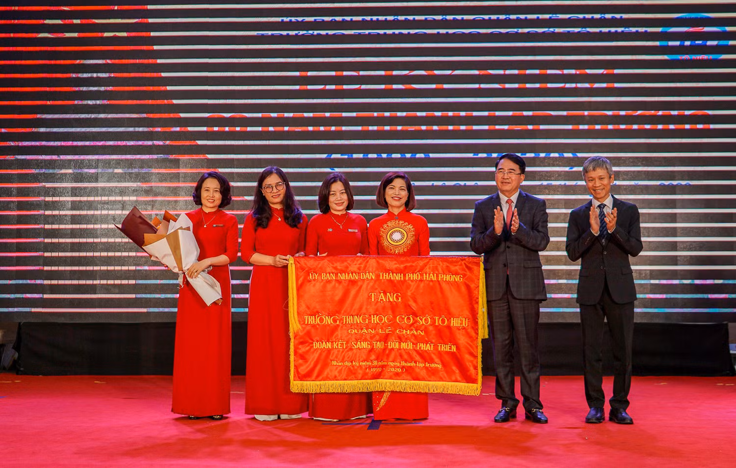 Ông Lê Khắc Nam, Phó chủ tịch Ủy ban nhân dân thành phố Hải Phòng trao tặng tập thể lãnh đạo, thầy và trò Trường Trung học cơ sở Tô Hiệu bức trướng mang dòng chữ: “Đoàn kết - Sáng tạo - Đổi mới - Phát triển”. (Ảnh: LH)