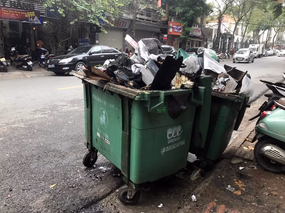 Tình trạng các thùng rác không được đậy nắp gây mất mĩ quan trên nhiều tuyến phố Hà Nội. Ảnh: TD.