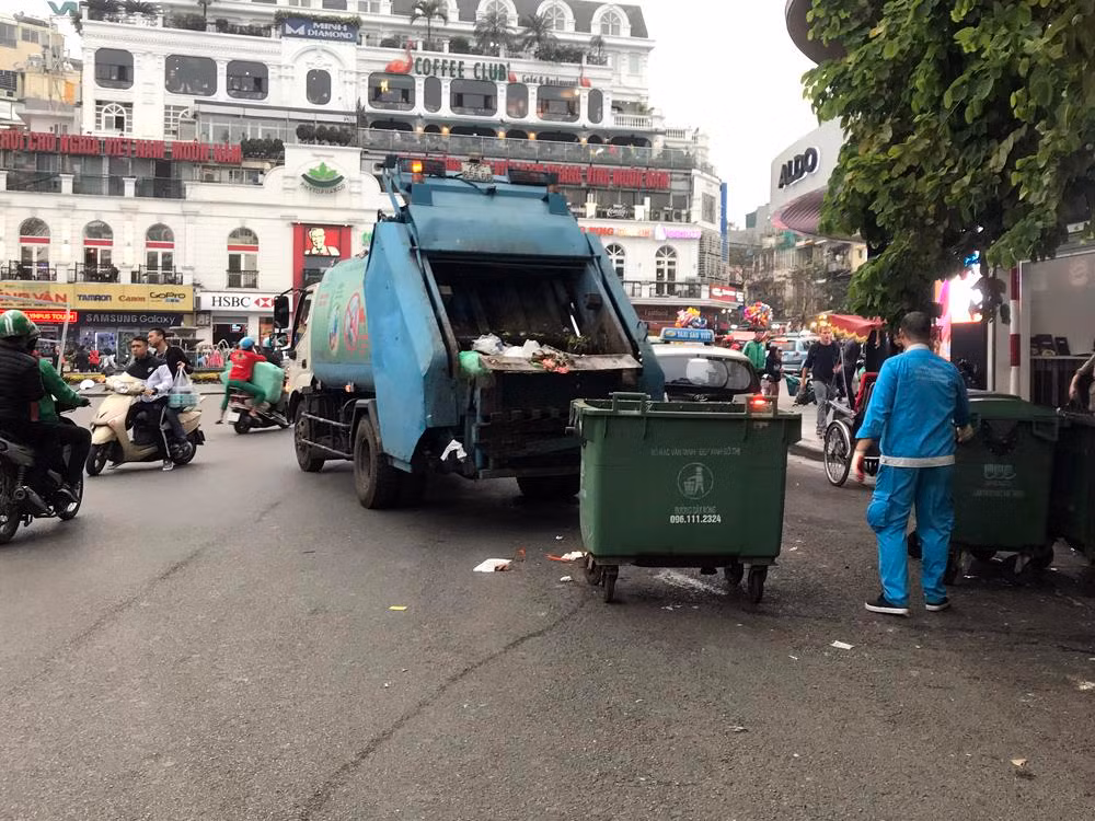Xe ô tô gom rác đỗ chéo giữa đường để thu gom gây cản trở giao thông. Ảnh: TD.