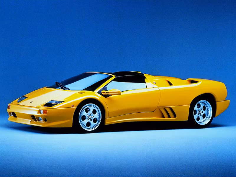 3. Lamborghini Diablo (1990 - 2001) Nhắc đến siêu xe của Lamborghini, đặc biệt là trong thập niên 90 của thế kỷ trước, cái tên nổi nhất chắc chắn là Diablo. Đây là mẫu xe kế nhiệm của Countach, và cũng là siêu xe đầu tiên của Lamborghini đạt vận tốc tối đa trên 200 dặm/h (320 km/h). Diablo được phát triển từ Dự án 132 khởi động vào năm 1985, và vẫn như truyền thống của Lamborghini, nó được đặt tên theo một giống bò tót. Chiếc Diablo đầu tiên ra mắt công chúng vào ngày 21/1/1990 với giá bán 240.000 USD và thuộc thế hệ Diablo thứ I. Xe sử dụng động cơ V12 5,7 lít, cho công suất 492 mã lực. Diablo có thể tăng tốc từ 0 lên 100 km/h trong 4,5 giây và đạt vận tốc tối đa 202 dặm/h (325 km/h). Cùng trong thế hệ này có những phiên bản như Diablo VT, Diablo SE30 và SE 30 Jota, Diablo SV và Diablo VT Roadster. Thế hệ thứ II của Diablo bắt đầu với Diablo SV vào năm 1999. Lúc này Lamborghini đã dừng mẫu Diablo cơ bản, Diablo SV trở thành phiên bản tiêu chuẩn của dòng Diablo. Điểm khác biệt dễ thấy giữa thế hệ này với thế hệ trước là Diablo không còn dùng kiểu đèn pha mắt ếch như trên đời cũ. Nội thất của Diablo SV cũng có một số thay đổi, và đặc biệt là động cơ được tăng lên đến 530 mã lực. Sau Diablo SV, Lamborghini lần lượt sản xuất thêm các phiên bản Giablo VT/VT Roadster, Diablo GT, Diablo VT 6.0/VT 6.0 SE. Ngoài ra, hãng siêu xe Ý còn xuất xưởng một số phiên bản đặc biệt cho đường đua chuyên nghiệp như Diablo SV-R hay Diablo GTR. Lamborghini đã sản xuất cả thảy 2.884 chiếc Diablo trước khi nhường ánh hào quang lại cho dòng xe Lamborghini Murciélago nổi tiếng.