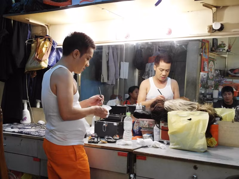 Minh Nhí, người thầy của nhiều thế hệ diễn viên, đang đứng trước bàn trang điểm.