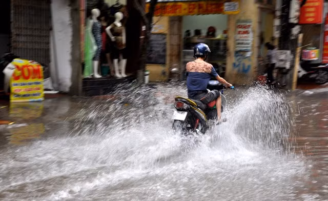 Trên phố Trần Bình (Cầu Giấy, Hà Nội), nước ngập tràn tới mép cửa nhà các hộ dân ven đường. Các phương tiện lưu thông qua đây gặp rất nhiều khó khăn.