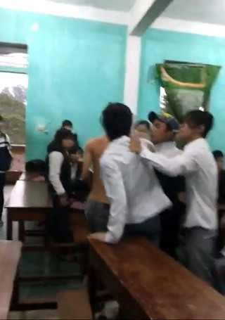 Không những không can ngăn bạn đánh bạn nữ trong lớp mà một số nam sinh khác còn kích động và hút thuốc phì phèo ngay trong lớp học (ảnh cắt từ clip) Không những không can ngăn bạn đánh bạn nữ trong lớp mà một số nam sinh khác còn kích động và hút thuốc phì phèo ngay trong lớp học (ảnh cắt từ clip)
