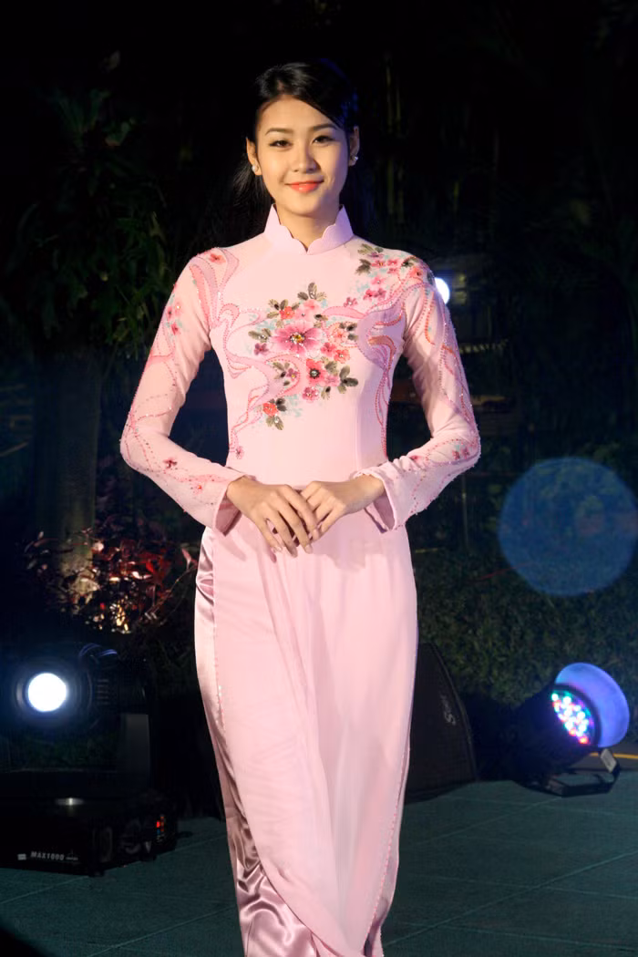 Sắc Xuân tươi thắm và lộng lẫy với bộ áo dài màu hồng phấn này! Nét độc đáo của chiếc áo chính là phần cách điệu của cổ áo.