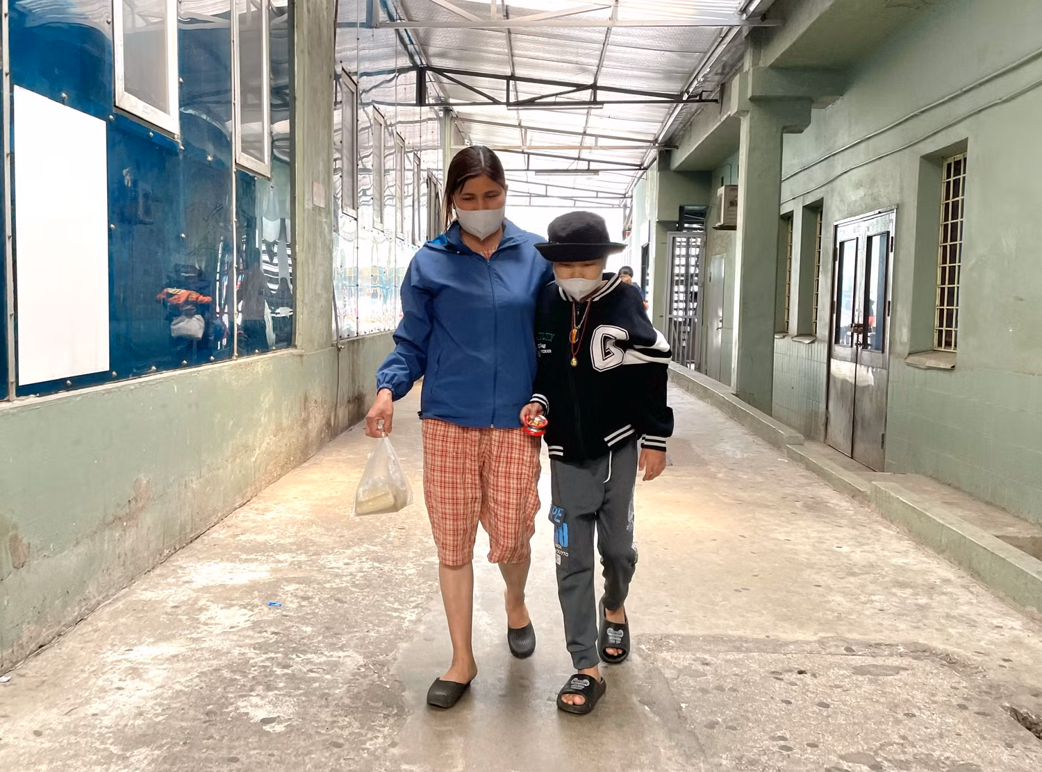 Hai mẹ con mua thức ăn cho bữa trưa trong bệnh viện. Ảnh: Mộc Trà. Hai mẹ con mua thức ăn cho bữa trưa trong bệnh viện. Ảnh: Mộc Trà.