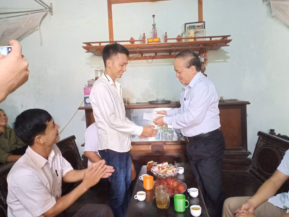 Ông Lưu Vũ Lâm (bên phải) trao quà cá nhân cho cựu học sinh Nguyễn Phú Dung. Ảnh của Thanh Minh.