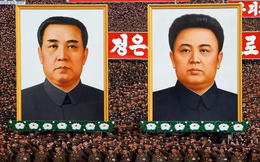 Binh sĩ Triều Tiên mang theo bức chân dung khổng lồ của hai nhà lãnh đạo Kim Il-Sung và Kim Jong-il.