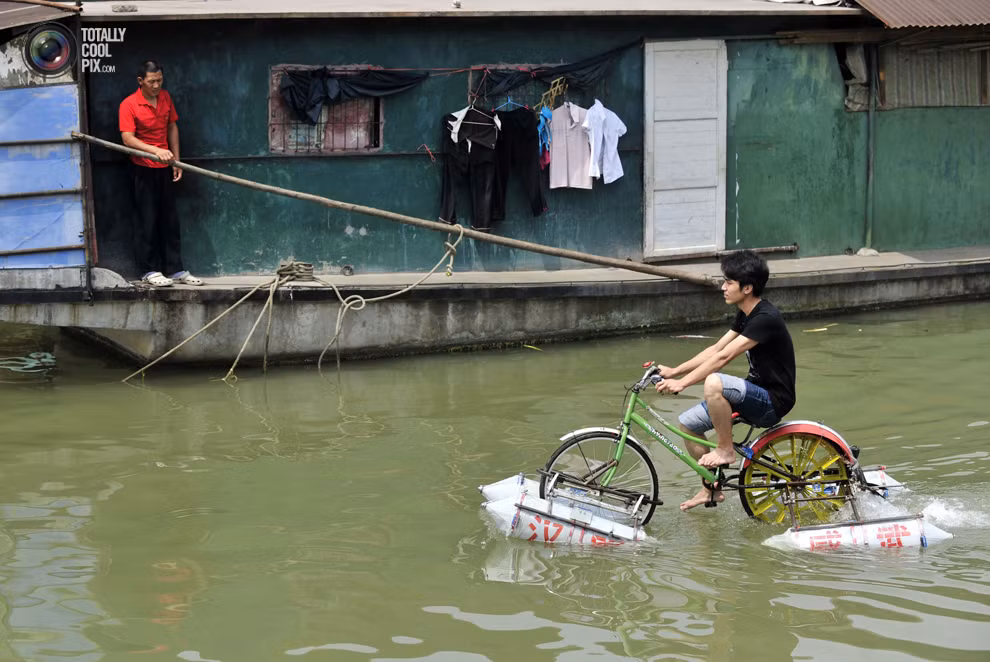 Một thanh niên Vũ Hán chế ra chiếc "xe đạp lội nước" đi trên sông Hán Giang, một nhánh của sông Dương Tử tại Vũ Hán, tỉnh Hồ Bắc.