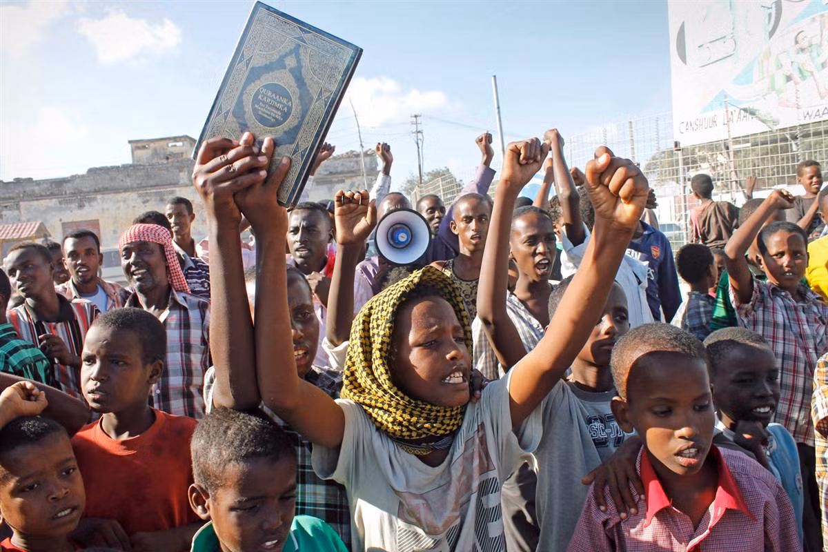 Tại thành phố Mogadishu, Somalia, các thanh niên và trẻ em Somali giờ lên cao một bản sao của kinh Koran trong một cuộc biểu tình. Bộ phim của nhà sản xuất Mỹ bị cho là đã bôi xấu Hồi giáo khi mô tả nhà tiên tri Muhammad như là một người gian lận, một kẻ lăng nhăng và một người điên. Tại thành phố Mogadishu, Somalia, các thanh niên và trẻ em Somali giờ lên cao một bản sao của kinh Koran trong một cuộc biểu tình. Bộ phim của nhà sản xuất Mỹ bị cho là đã bôi xấu Hồi giáo khi mô tả nhà tiên tri Muhammad như là một người gian lận, một kẻ lăng nhăng và một người điên.