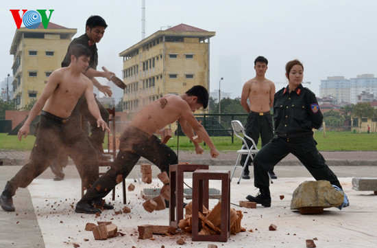 trong khi đồng đội dùng búa công phá gạch