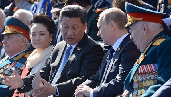 Vợ chồng nhà lãnh đạo Trung Quốc Tập Cận Bình ngồi cạnh Tổng thống Putin trên khán đài.
