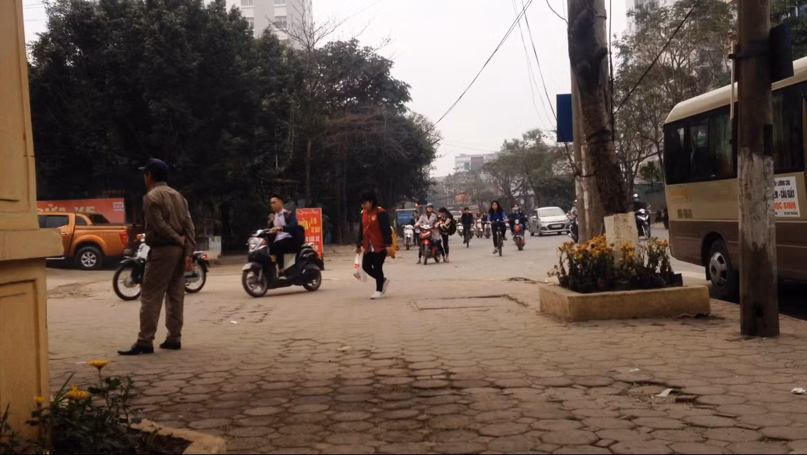Học sinh đầu không đội mũ bảo hiểm đi xe gắn máy phân khối lớn đi lên vỉa hè. Ảnh: Công Tiến.
