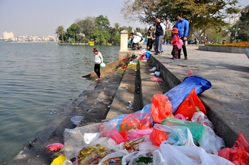 Thả cá chép, thả cả túi nilông (Ảnh: Trần Kháng)