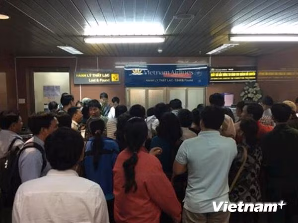 Rất đông hành khách tụ tập trước quầy bán vé để phản đổi cách xử lý tình huống của Vietnam Airlines. (Ảnh: PV/Vietnam+) Rất đông hành khách tụ tập trước quầy bán vé để phản đổi cách xử lý tình huống của Vietnam Airlines. (Ảnh: PV/Vietnam+)