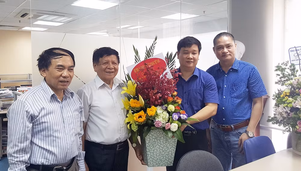 Phó Giáo sư Trần Xuân Nhĩ (thứ 2 từ trái qua), Tiến sĩ Văn Đình Ưng (ngoài cùng bên trái) thay mặt Hiệp hội Đại học và Cao đẳng Việt Nam tới thăm và chúc mừng Báo.