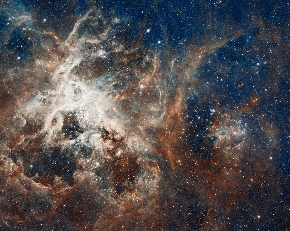 Tinh vân nhện Rarantula cách trái đất 170.000 năm ánh sáng. Kính thiên văn Hubble đã chụp được hình ảnh rõ nét của từng ngôi sao trong chòm sao mới sinh. Hình ảnh này như một bức tranh phong cảnh hung vĩ với những cột mây, rặng núi và thung lũng. Những ngôi sao lớn hiện lên rất rõ nét nhờ ánh sáng tia cực tím đã sàng lọc đám mây khí xung quanh