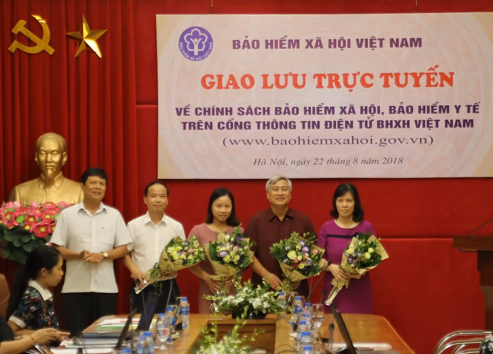 Các khách mời tham gia giải đáp thắc mắc cho người lao động, người sử dụng lao động lên nhận hoa của ban tổ chức.