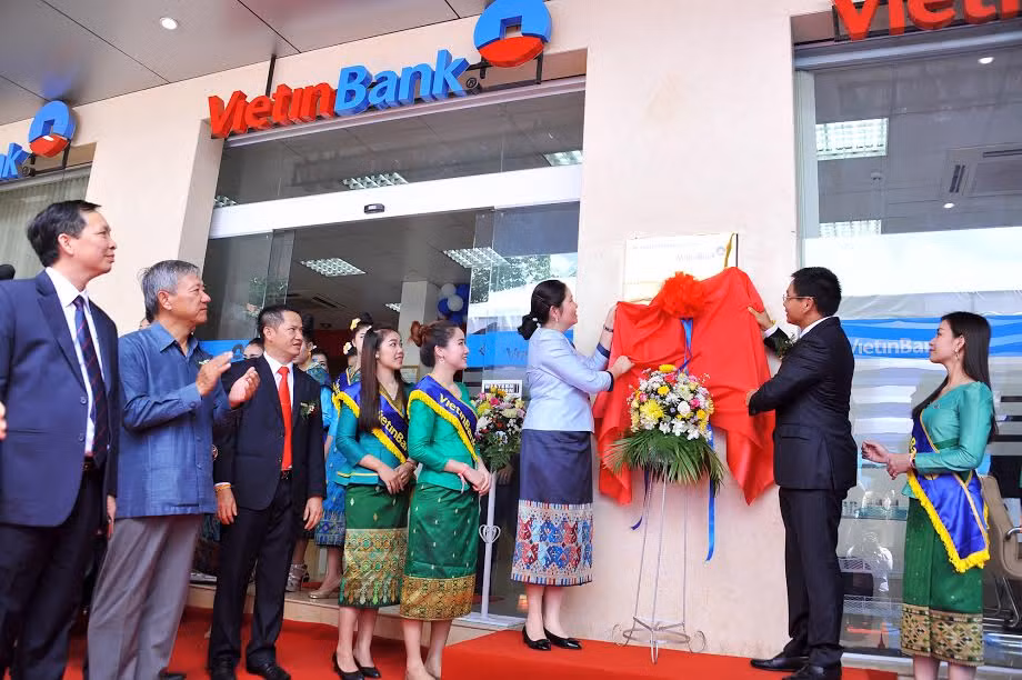 Đại biểu thực hiện nghi thức kéo biển khai trương Chi nhánh Champasak.