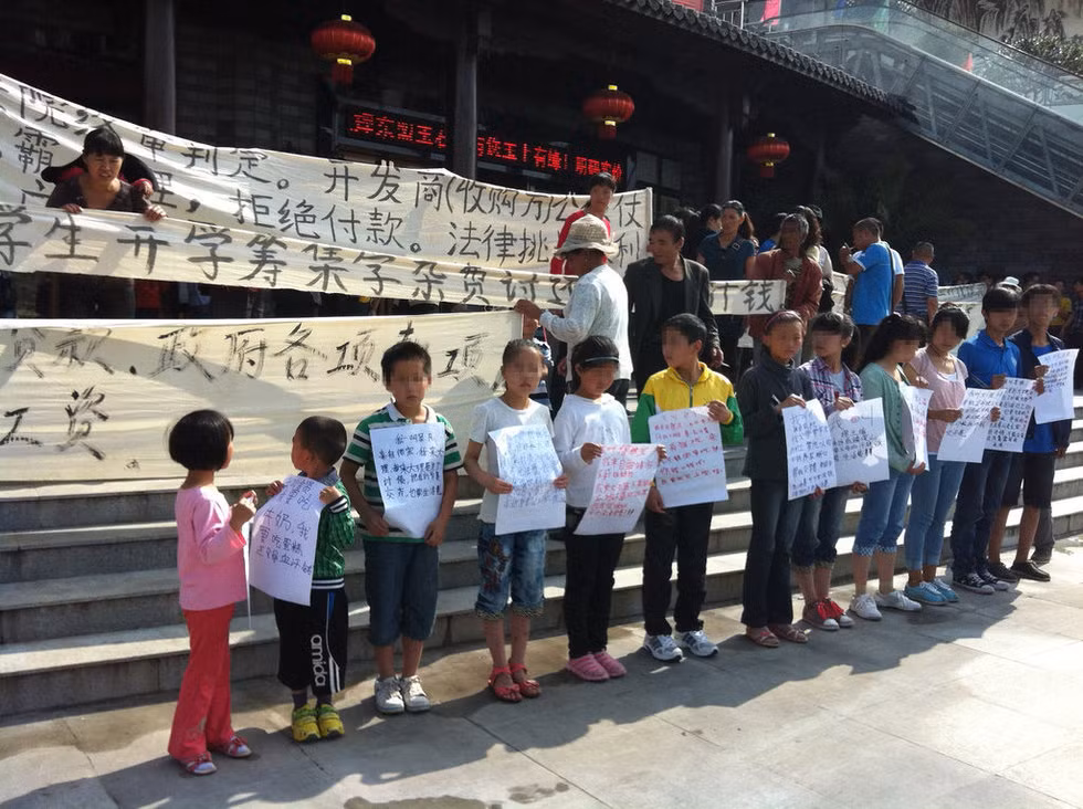 Đứa nhỏ nhất mới có 5 tuổi cầm tờ biểu ngữ viết tay nghuệch ngoạc: "Cháu cần uống sữa! Hãy trả tiền bố mẹ cháu!"