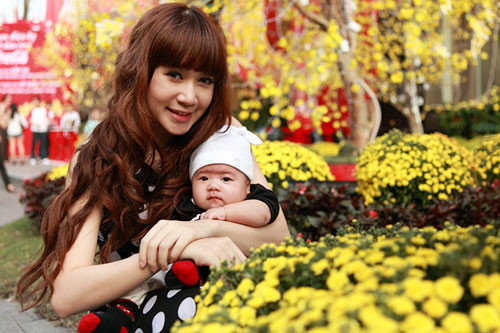 Minh Hà, vợ Lý Hải chiều qua đã bồng con trai 3 tháng tuổi đi sắm Tết tại Trung tâm thương mại Vincom (TP.HCM) rồi ra đường hoa Nguyễn Huệ. Bé Rio Hạo Nhiên diện chiếc áo thun đen, đội mũ nhìn chững chạc hơn so với 3 tháng tuổi. Trong khi đó Minh Hà đã lấy lại được vóc dáng gọn gàng, mảnh mai. Cô mặc chiếc váy chấm bi rất nổi bật. (Nguồn: Zing).