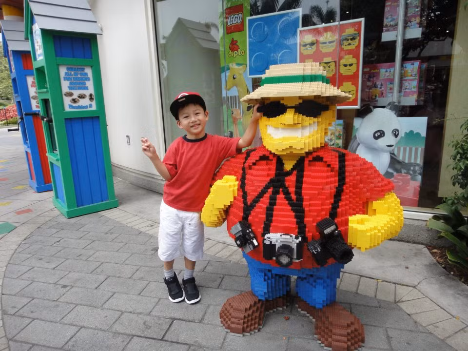 Cậu bé nhí nhảnh chụp ảnh bên những bức tượng hài hước tại Legoland.