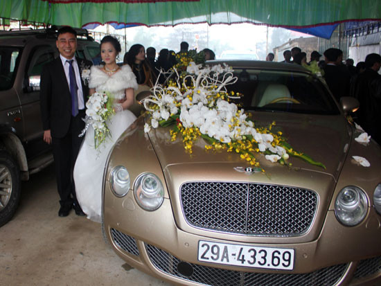 Cô dâu chú rể bên chiếc xe hoa sang trọng.