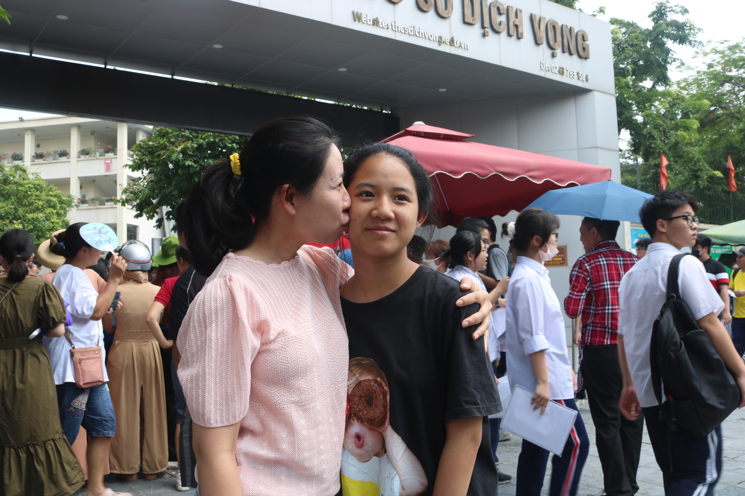 Người mẹ dành nụ hôn lên má chúc mừng cô con gái đã vượt qua kỳ thi căng thẳng. (Ảnh: Phương Nga).