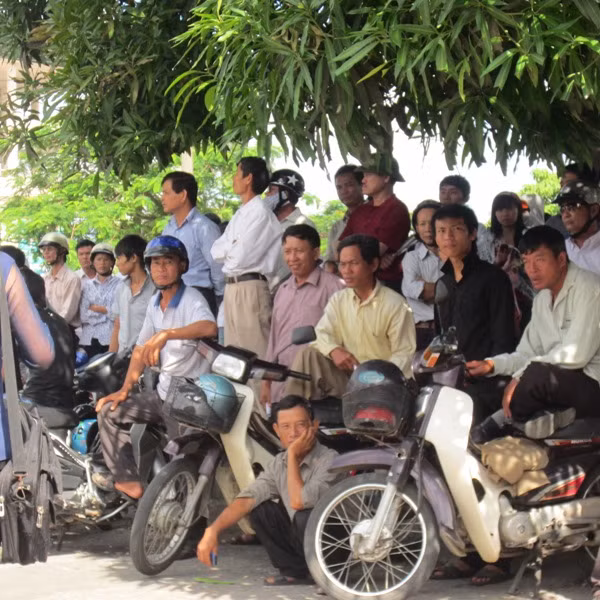Kẻ đứng, người ngồi lo lắng cho những đứa con của mình đang làm bài trong phòng thi. (Xem đáp án môn Vật lí - Xem đáp án môn Toán)