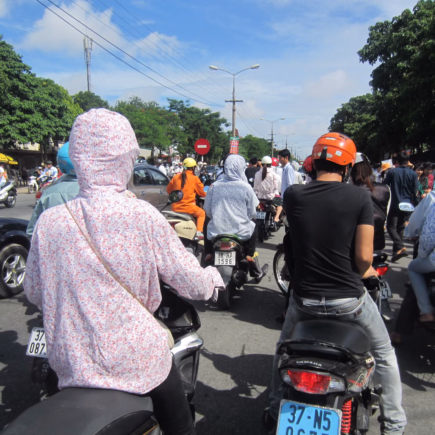 Các phụ vất vả len lỏi giữa dòng xe ùn tắc và nắng nóng để đưa con mình về nơi nghỉ ngơi chuẩn bị cho buổi thi tiếp theo.