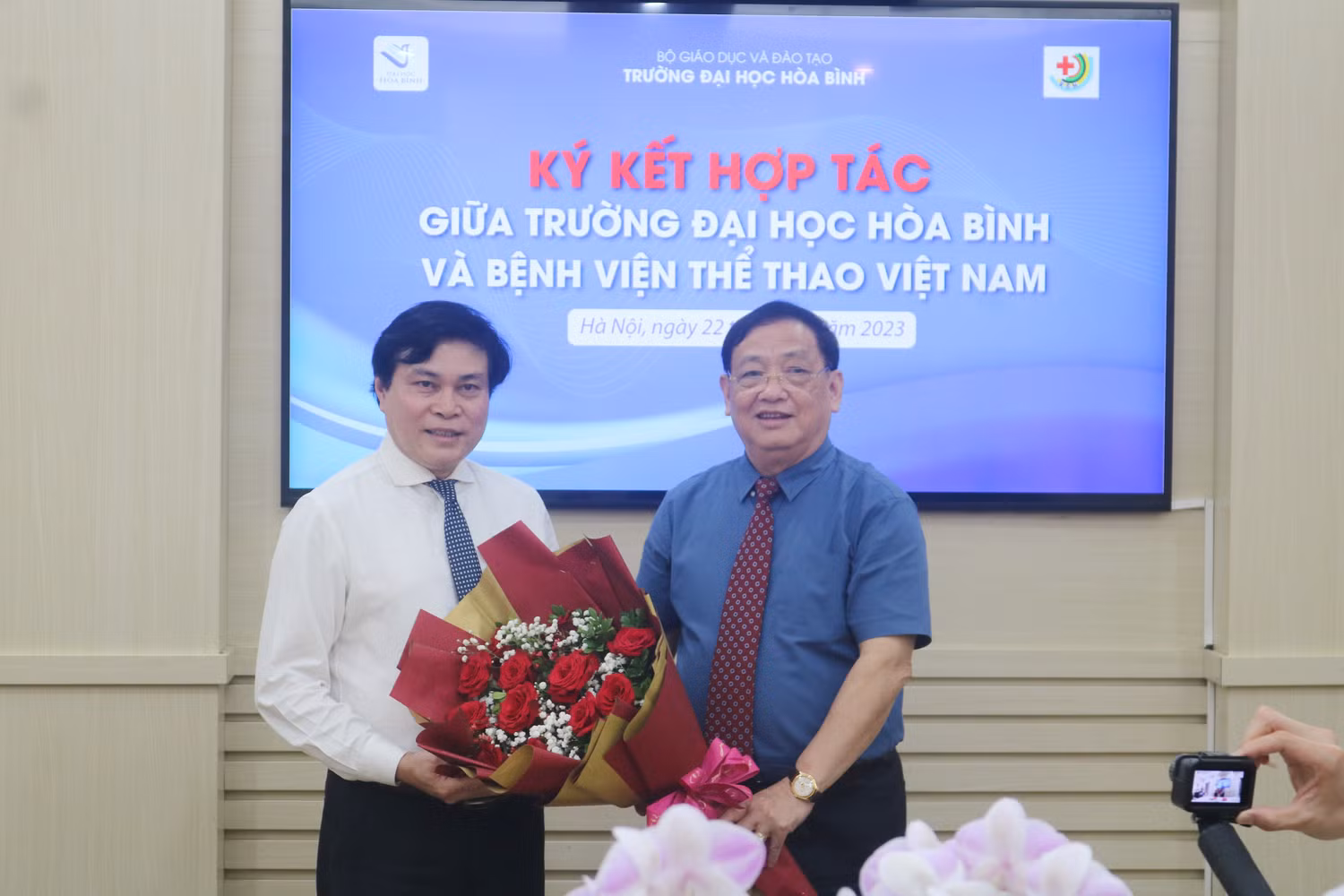 Hiệu trưởng Trường Đại học Hòa Bình tặng hoa Giám đốc Bệnh viện Thể thao Việt Nam. Ảnh: DN