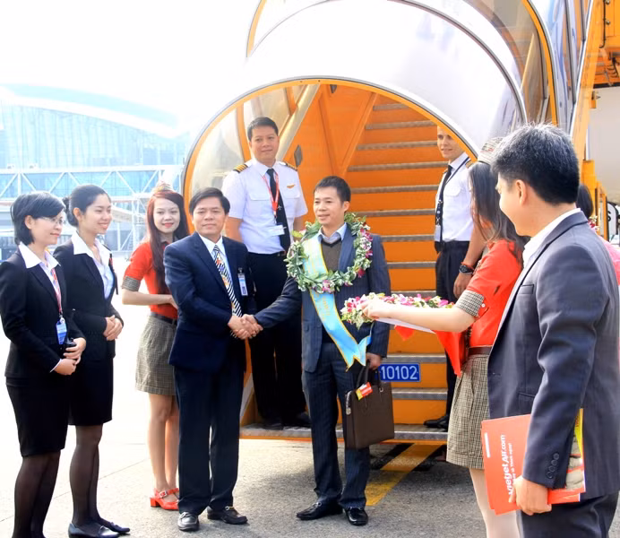 Hành khách thứ 5 triệu (ở giữa) may mắn nhận được 1 năm bay miễn phí cùng Vietjet. Ảnh Thùy Linh Hành khách thứ 5 triệu (ở giữa) may mắn nhận được 1 năm bay miễn phí cùng Vietjet. Ảnh Thùy Linh