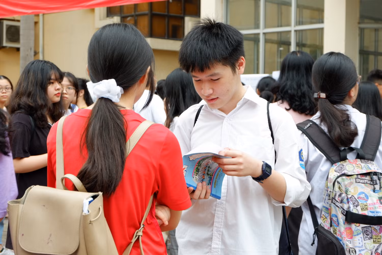 Nhiều thí sinh đến sớm đã tranh thủ ôn lại kiến thức trước khi bước vào phòng thi. Ảnh: Thu Trà