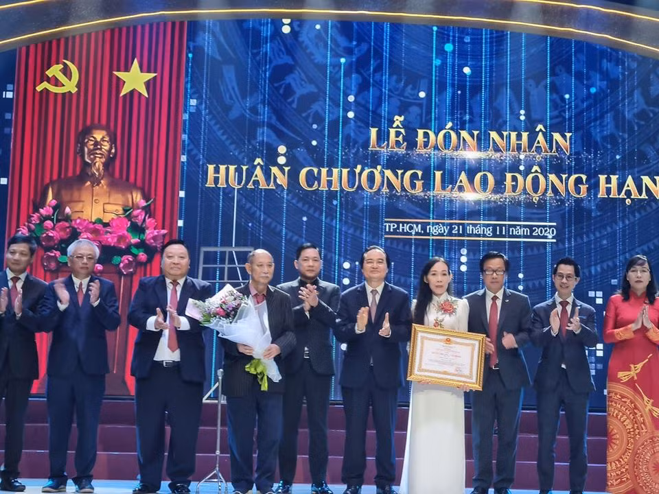 Bộ trưởng Phùng Xuân Nhạ (thứ 5, phải sang) trao Huân chương Lao động Hạng Ba cho trường (ảnh: P.L)