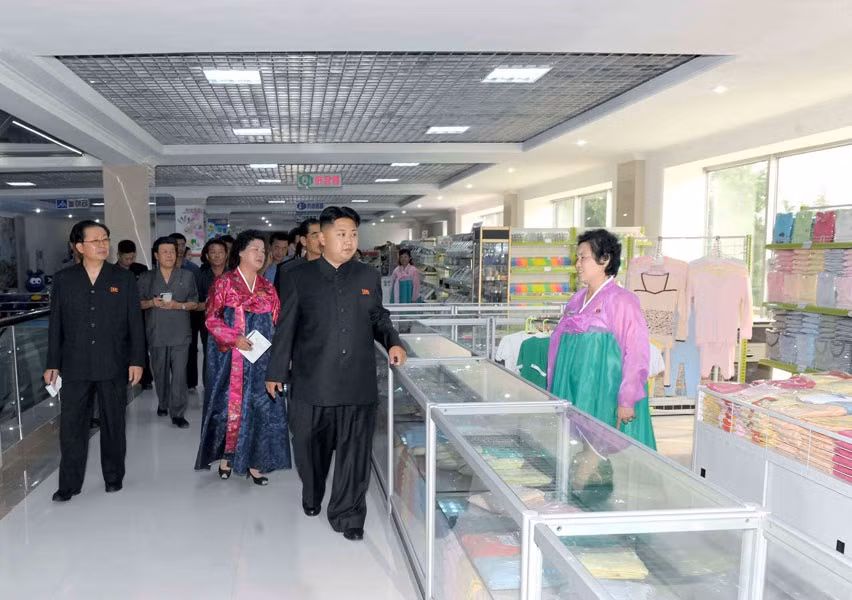Những quản lý quầy hàng trong trang phục truyền thống đón lãnh đạo tối cao