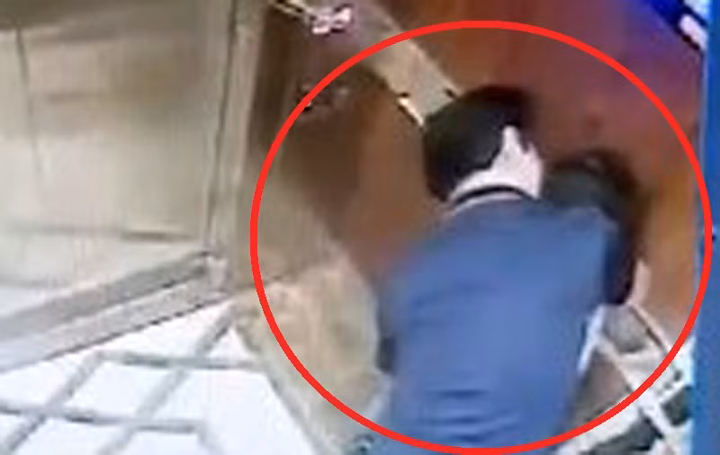 Hình ảnh người đàn ông ôm ấp bé gái trong thang máy qua màn hình camera. (Ảnh cắt từ clip)