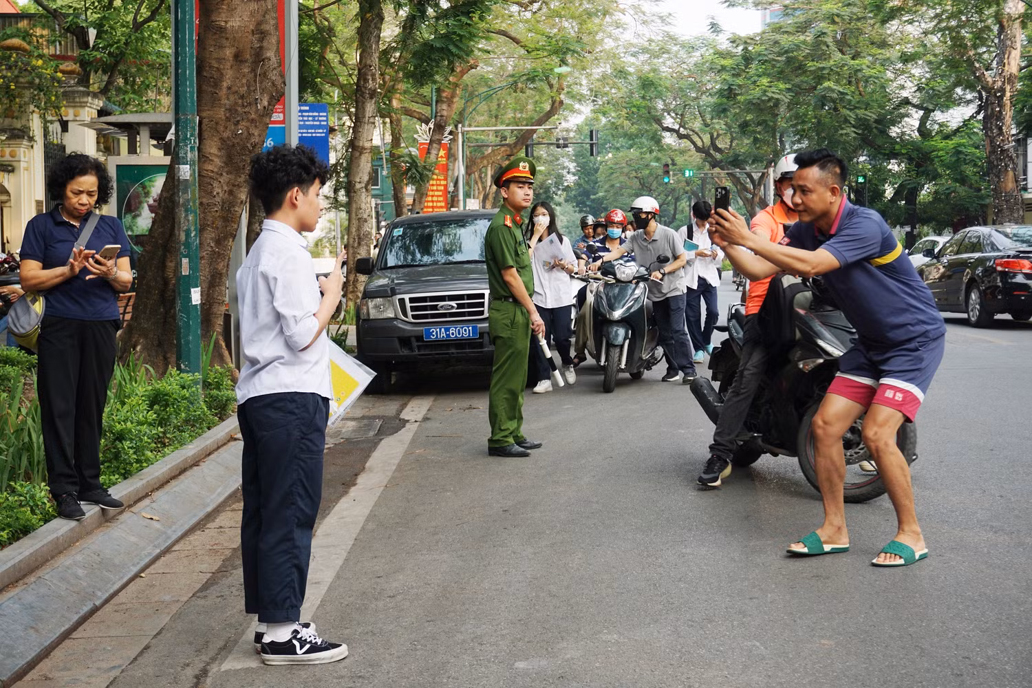 Bố chụp ảnh kỷ niệm cho con trai trước khi bước vào kỳ thi tại điểm thi Trường Trung học phổ thông Việt Đức. Ảnh: Phạm Minh
