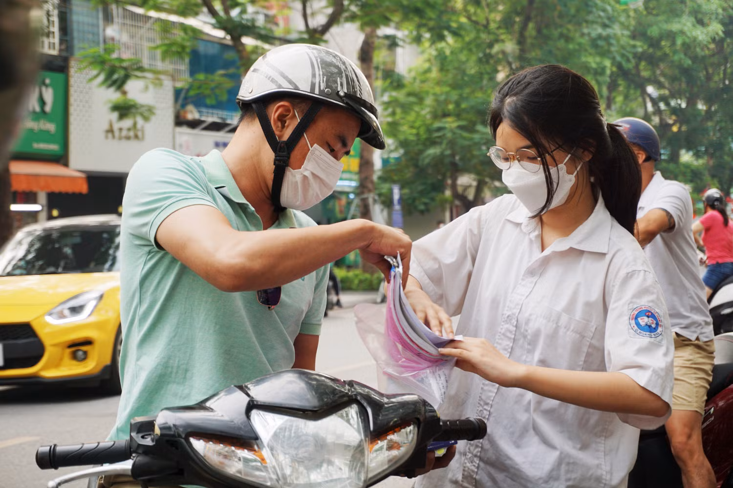 Thí sinh gửi lại đồ cho bố trước khi bước vào phòng thi. Ảnh: Phạm Minh