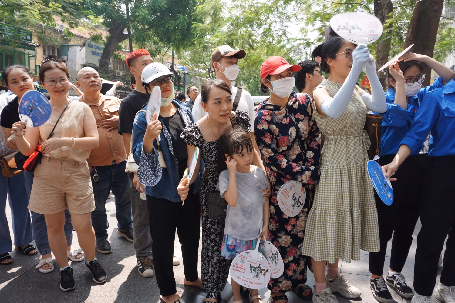 Em nhỏ cùng bố mẹ chờ đợi để đón anh chị của mình. Ảnh: Phạm Minh
