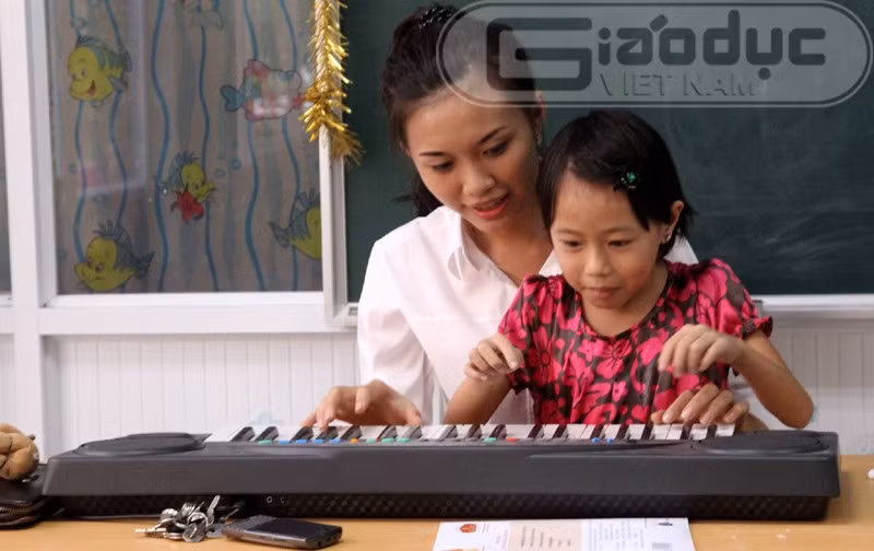 Hồ Thị Phương Thảo chơi đàn cùng một bé gái