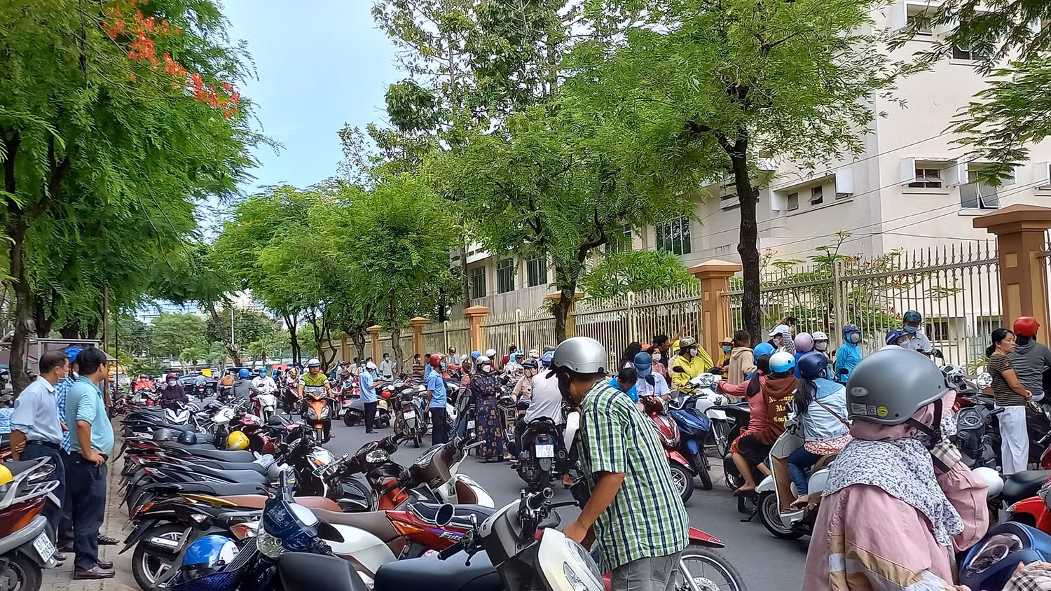 Thời tiết khá nắng, nóng nhưng phụ huynh vẫn kiên nhẫn đứng chờ con trước cổng trường. Ảnh: K.V Thời tiết khá nắng, nóng nhưng phụ huynh vẫn kiên nhẫn đứng chờ con trước cổng trường. Ảnh: K.V