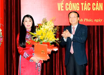 Ông Tô Huy Rứa trao quyết định của Bộ Chính trị cho bà Hoàng Thị Thúy Lan. ảnh: Báo Vĩnh Phúc.