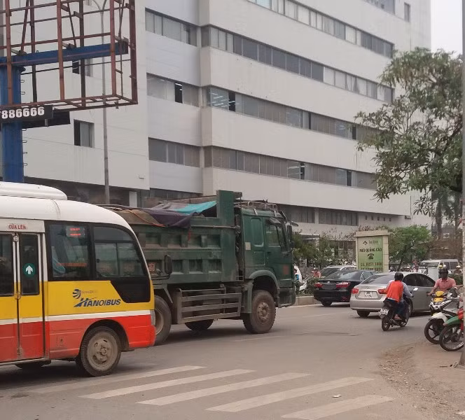 Mặc dù lực lượng chức năng đang xử lý vụ tai nạn nhưng xe quá tải vẫn ngang nhiên "vượt rào" tại ngã tư Phạm Hùng - Tôn Thất Thuyết.
